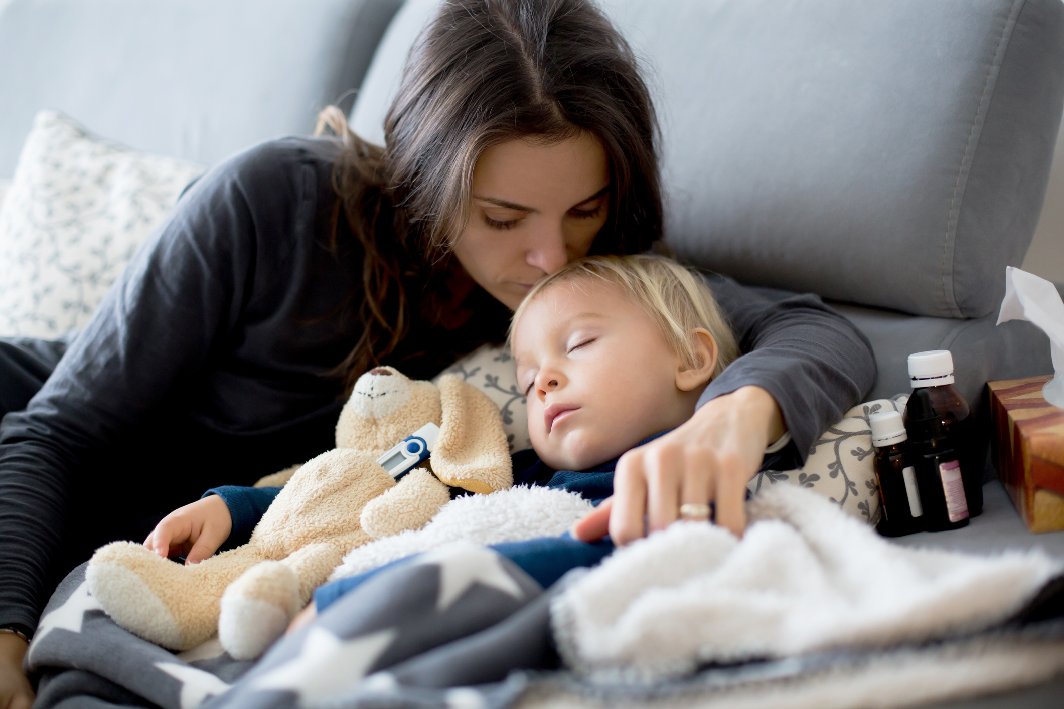 Mutter und Kind kuscheln auf dem Sofa.